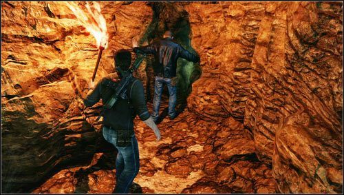Z pochodnią w ręku ruszamy jaskinią i przepychamy przed sobą wciąż odurzonego Charliego przez wąską szczelinę [1] - Rozdział 9- Droga środka | Opis przejścia Uncharted 3 Oszustwo Drakea - Uncharted 3: Oszustwo Drakea - poradnik do gry