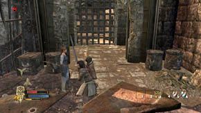 Po lewej jest skrzynia, po prawej stos przedmiotów (przeszukaj jedno i drugie), wokół sporo beczek i skrzynek, naprzeciwko zaś druga balista, którą zepchnij - Mury obronne | Rozdział 1 | Władca Pierścieni Wojna na Północy - Władca Pierścieni: Wojna na Północy - poradnik do gry