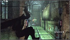 Ustaw się na wprost od płyt pod napięciem, wyjmij z inwentarza wyrzutnię lin i wyceluj w widoczną w oddali ścianę #1 - Szarada Enigmy (4) | Misje poboczne w Batman Arkham City - Batman: Arkham City - poradnik do gry