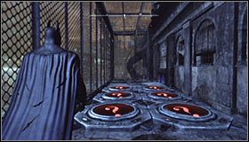 Po dotarciu na miejsce powinieneś zauważyć, że trofeum znajduje się wewnątrz dużej klatki #1 i że dostępu do niego blokują czerwone płyty naciskowe #2, których nie można dotknąć - Mila Rozrywki - Trofea Batmana (21-30) | Zagadki w Batman Arkham City - Batman: Arkham City - poradnik do gry