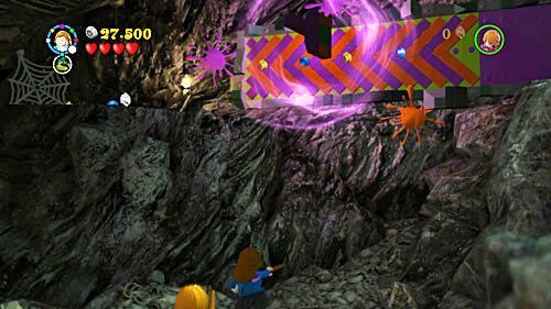 Używamy w odpowiednim miejscu torebki Hermiony, wyciągamy z niej pędzel, którym usuwamy farbę z kolorowej ściany - Paląc mosty (2) | Opis przejścia - Rok 7 | LEGO Harry Potter Lata 5-7 - LEGO Harry Potter: Lata 5-7 - poradnik do gry