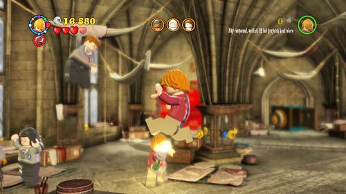 W sali życzeń po prawej stronie pod sufitem wisi uczeń, aby go uratować należy strzelić do niego z różdżki - Powrót do szkoły | Znajdźki - Rok 7 | LEGO Harry Potter Lata 5-7 - LEGO Harry Potter: Lata 5-7 - poradnik do gry