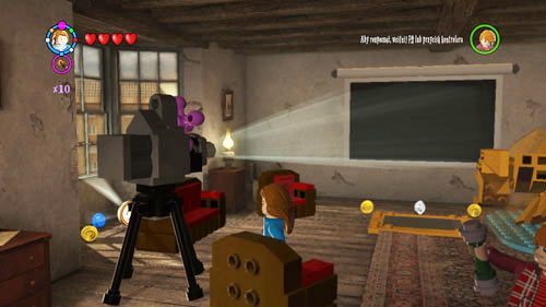 Dziurawy Kocioł - na piętrze przechodzimy do końca korytarz i skręcamy w lewo, trafimy do pokoju filmowego, za fotelem leży szton Pani Figg - Dodatkowe sztony postaci - Londyn (1) | Dodatkowe znajdźki | LEGO HP Lata 5-7 - LEGO Harry Potter: Lata 5-7 - poradnik do gry