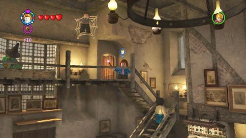 Dziurawy kocioł - pod sufitem znajdziemy kolejnego ucznia, zawieszony będzie on na pajęczynie, musimy strzelić w niego aby spadł - Uczniowie w niebezpieczeństwie (1) | Dodatkowe znajdźki | LEGO HP Lata 5-7 - LEGO Harry Potter: Lata 5-7 - poradnik do gry