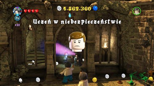 Okrągły dziedziniec - na prawo od wejścia do sali, wisi student - Uczniowie w niebezpieczeństwie (2) | Dodatkowe znajdźki | LEGO HP Lata 5-7 - LEGO Harry Potter: Lata 5-7 - poradnik do gry