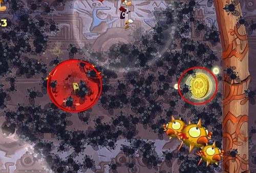 Po dotarciu na dół uderz w pierścień po prawej stronie i spadnij na dół do kolejnej M - Dzikie roje (300 L, 2:10) | Ględzoce Groty | Rayman Origins - Rayman Origins - poradnik do gry