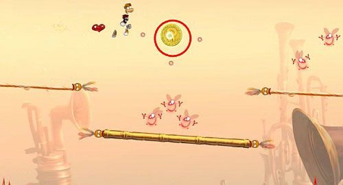 Za drzwiami zniszcz ostatnią klatkę z E na tym poziomie - Nie strzelaj do DJ-a (300 L); Wysokie napięcie (300 L, 1:45) | Ględzoce Groty - Rayman Origins - poradnik do gry