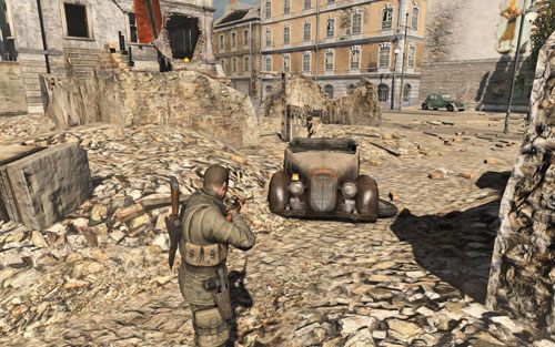 Na prawym reflektorze samochodu [#5], który miniesz po lewej przechodząc do kolejnego budynku - Prolog; Misja 1 | Butelki i Sztaby złota Sniper Elite V2 - Sniper Elite V2 - poradnik do gry