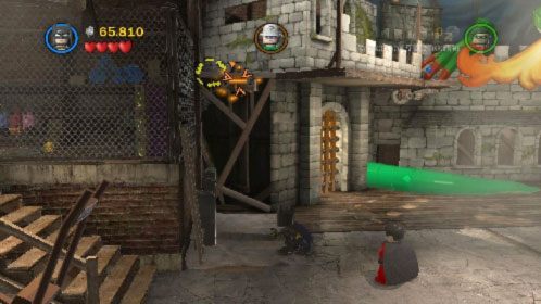 Kiedy twój przeciwnik wyjdzie z instrumentu przejdź do pomieszczenia z prawej, gdzie znajduje się sceneria z zamkiem - Na deskach teatru | Opis przejścia LEGO Batman 2 DC Super Heroes - LEGO Batman 2: DC Super Heroes - poradnik do gry