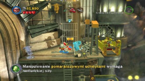 Rozpraw się z przeciwnikami, po czym użyj magnezu, aby opuścić na dół windę (obrazek) (części które spadną, przydadzą ci się w naprawie śmigłowca) - Współudział | Opis przejścia LEGO Batman 2 DC Super Heroes - LEGO Batman 2: DC Super Heroes - poradnik do gry