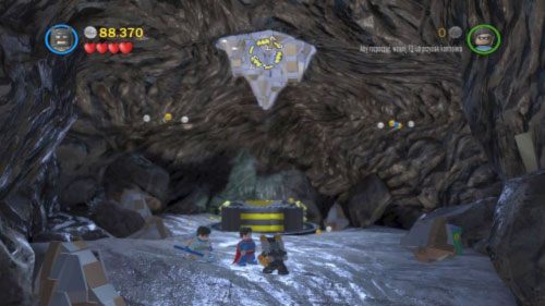 Użyj uchwytu, aby dostać się po dinozaurze na górę, po czym zniszcz granatem srebrną skałę (obrazek) - Nieproszeni goście | Opis przejścia LEGO Batman 2 DC Super Heroes - LEGO Batman 2: DC Super Heroes - poradnik do gry