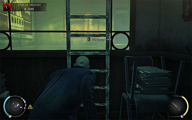 Omiń osoby przebywające w pomieszczeniu na parterze i zlokalizuj pokazaną na powyższym screenie drabinę, dzięki której przedostaniesz się na wyższy poziom budynku - Uruchomienie semaforów kolejowych (Stacja kolejki) | 4 - Uciekaj, by przeżyć - Hitman Absolution - poradnik do gry