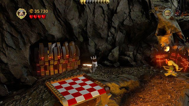 Po zrzuceniu głazu do rzeki lawy możemy stanąć obok posadzki i zniszczyć mieczem Aragorna znajdujące się tam LEGO Morgulu - Prolog | Znajdźki | LEGO The Lord of the Rings - LEGO The Lord of the Rings: Władca Pierścieni - poradnik do gry