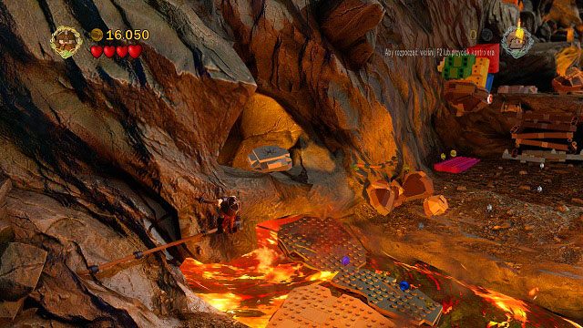 W miejscu, gdzie spadają kamienie, podczas przechodzenia przez rzekę ognia trzymając się poręczy zobaczymy popękaną płytkę LEGO - Góra Przeznaczenia | Znajdźki | LEGO The Lord of the Rings - LEGO The Lord of the Rings: Władca Pierścieni - poradnik do gry