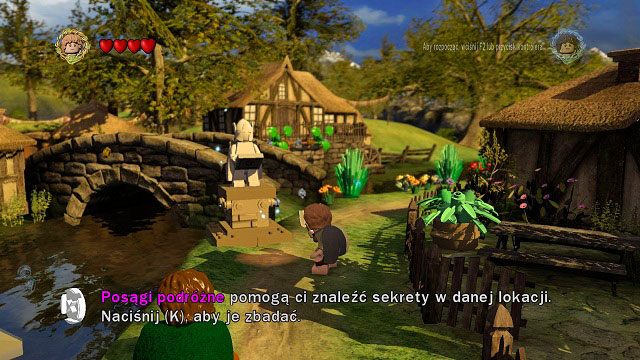 Mniej-więcej w centrum miasteczka znajdziemy jeden z wielu posągów podróżnych - Hobbiton (Śródziemie) | Opis przejścia - Akt I | LEGO The Lord of the Rings - LEGO The Lord of the Rings: Władca Pierścieni - poradnik do gry