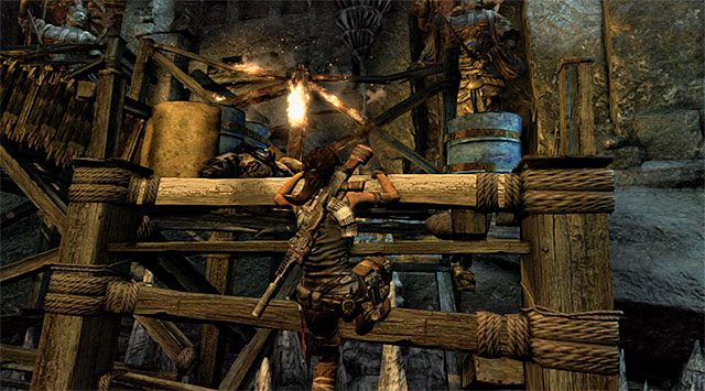 Pozbieraj amunicję i zbadaj ciała pokonanych wrogów, a następnie w pokazanym na screenie miejscu przedostań się na balkonik, na którym pojawiali się wcześniej kolejni bandyci - Opuść teren ośrodka badawczego | 23 - Łowca burz | Solucja Tomb Raider - Tomb Raider - poradnik do gry