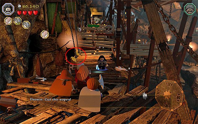 Przejdź po opuszczonym moście zwodzonym, rozpraw się z nowymi goblinami i zainteresuj się oznaczonymi na powyższym obrazku dwoma lewymi linami - Etap 7 (Goblin-town) - Ucieczka z Miasta Goblinów - LEGO The Hobbit - poradnik do gry