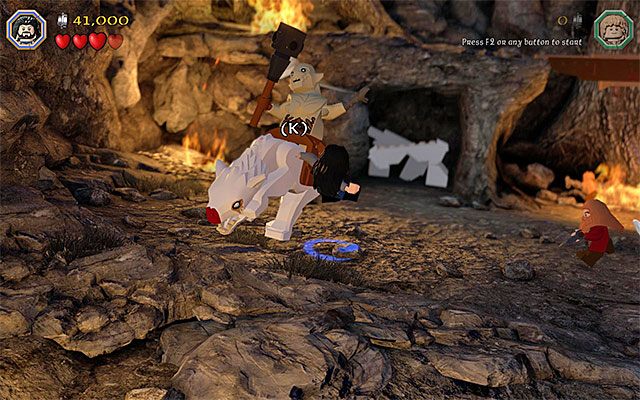 Wciskaj pokazywane klawisze, dzięki czemu dosiadany przez bossa wilk zostanie ogłuszony - Etap 8 (Out of the Frying Pan...) - Pojedynek z Azogiem Plugawym - LEGO The Hobbit - poradnik do gry