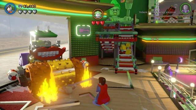 Podczas wjazdu Jokera podejdź do jego wozu i zniszcz złoty walec na środku laserem Supermana - Adam West / Czerwony klocek | Jutro O Tej Samej Batporze! - sekrety - LEGO Batman 3: Poza Gotham - poradnik do gry