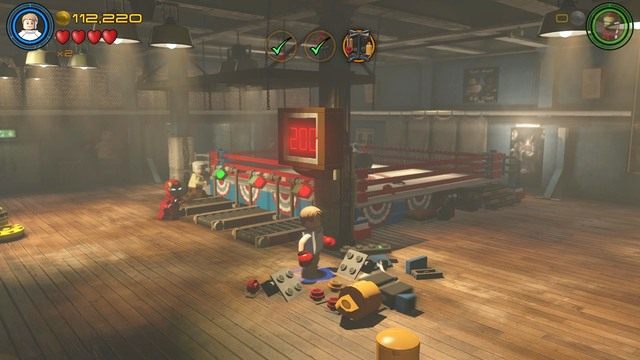 Po wykonanej czynności zejdź z ringu i stwórz z rozsypanych klocków konsolę, którą aktywuj na przykład jako Iron Man - Stan Lee / Czerwony klocek | Kolej na Hydrę - sekrety | LEGO Marvels Avengers - LEGO Marvels Avengers - poradnik do gry