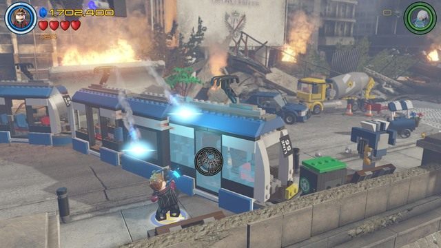 Podejdź do prawej strony blokującego drogą pociągu i strzel w stronę szklanej osłony jako Hawkeye - Stan Lee / Czerwony klocek | Świt Ultrona - sekrety | LEGO Marvels Avengers - LEGO Marvels Avengers - poradnik do gry