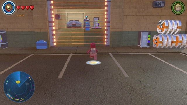 Zniszcz srebrne pojemniki po prawej stronie korzystając z ładunków wybuchowych po czym zmień postać na Visiona i dostań się do środka za pomocą kratki w ścianie - Złote klocki | Południowy Manhattan - sekrety | LEGO Marvels Avengers - LEGO Marvels Avengers - poradnik do gry