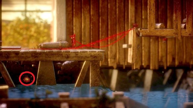 Guzik pod deskami, musisz użyć drewienka, by tam przepłynąć - Poziom 5 - Off the Rails | Sekrety w Unravel - guziki - Unravel - poradnik do gry