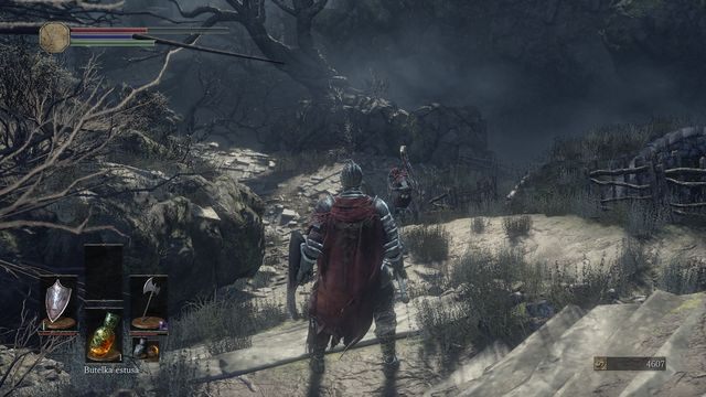 Zaraz za wspomnianym wyżej korytarzem wyjdziesz przez budynek. Odbij w prawo, aby znaleźć ognisko. - Osada Nieumarłych - od dużego placu, droga na wprost | Opis przejścia - Dark Souls III - opis przejścia i sekrety