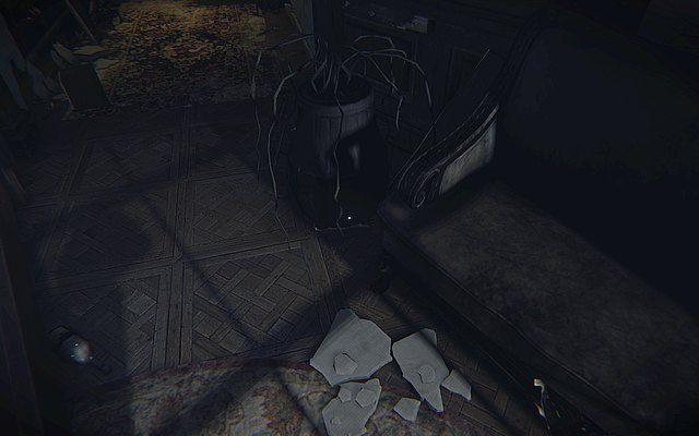 Krok piąty - po przejściu korytarza z dużą ilością drzwi, pomiędzy łóżkiem a doniczką z zeschłymi kwiatami, na podłodze - Pamiątki rodzinne | Sekrety Layers of Fear - Layers of Fear - poradnik do gry