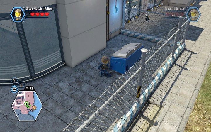 Śmietniki w niebiesko-białym kolorze często służą jako zabezpieczenie do przejścia przez siatkę - Wyspa więzienna | Rozdział 3 w Lego City: Tajny Agent - LEGO City: Tajny Agent - poradnik do gry