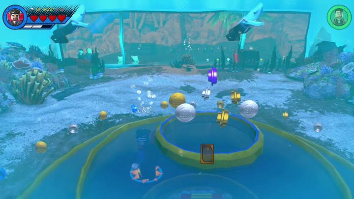 Zaraz po rozpoczęciu misji w trybie swobodnym, zniszcz pojemniki znajdujące się po lewej stronie i przejdź przez kratkę korzystając z postaci Ms - Misja 10 - Kąpiąc się w komiksach | Misje Gwenpool | Solucja - LEGO Marvel Super Heroes 2 - poradnik do gry