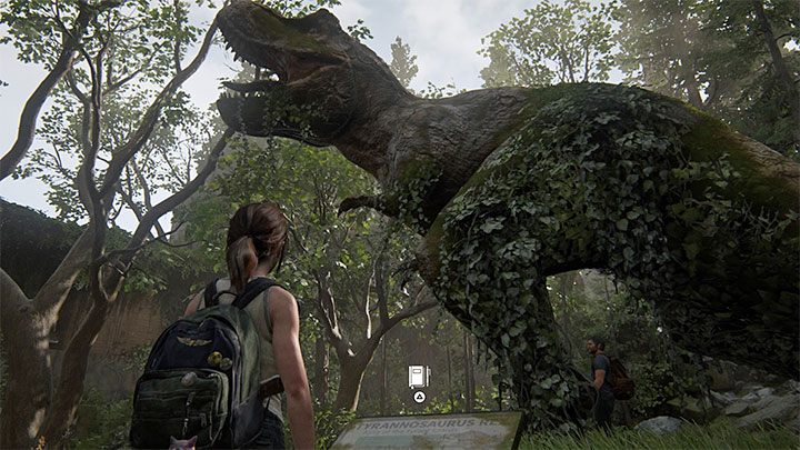 Podejdź do T-Rexa, wysłuchaj rozmowy Joela z Ellie i zaczekaj aż w pobliżu pokazanej na obrazku tabliczki informacyjnej pojawi się ikona dodania nowego wpisu do dziennika - The Last of Us 2: Prezent urodzinowy / The Birthday Gift sekrety, znajdźki - The Last of Us 2 - poradnik do gry