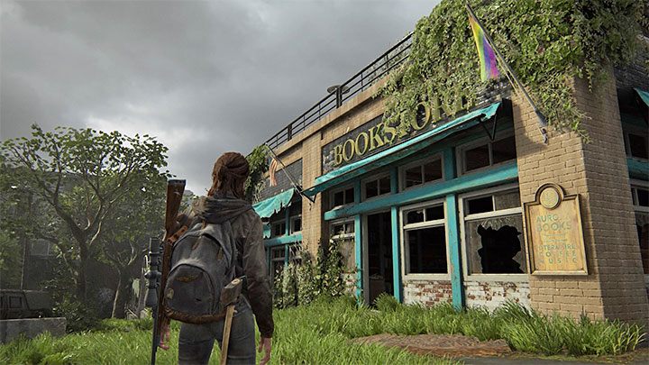 Zatrzymaj się dopiero po dotarciu do pokazanej na obrazku księgarni, którą rozpoznasz po wywieszonej obok niej fladze LBGT - The Last of Us 2: Podręczniki, umiejętności pasywne - The Last of Us 2 - poradnik do gry