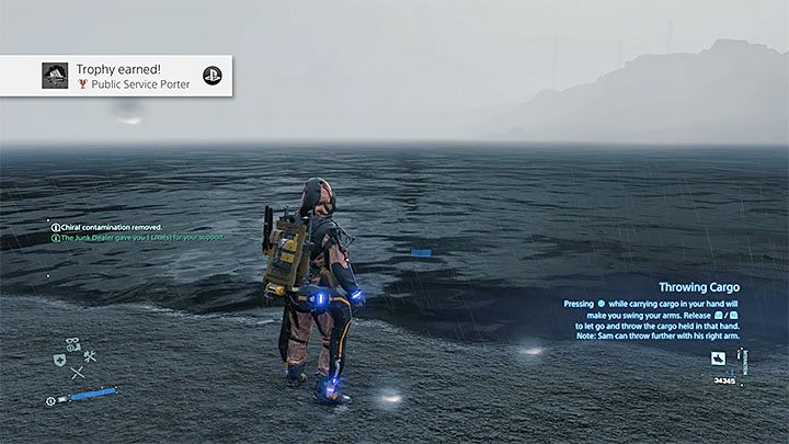 Trzymając ładunek (wciśnięty przycisk L2 i R2) wciśnij Kwadrat, dzięki czemu Sam rzuci pojemnikiem - Trofeum Dostawca usług publiicznych | Trofea i osiągnięcia w Death Stranding - Death Stranding - poradnik do gry