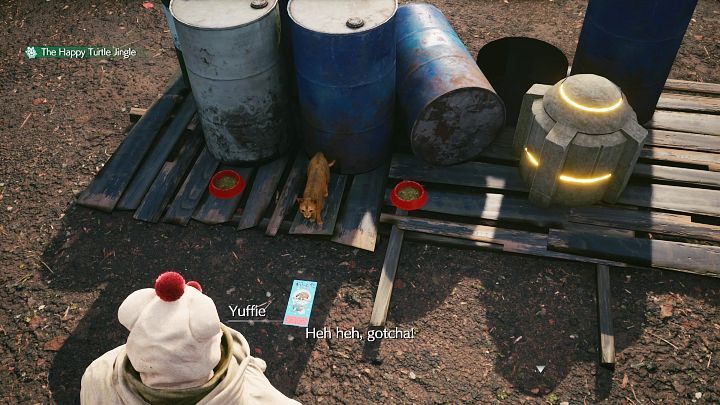 Przechodząc przez plac zauważycie, koty, które będą bawić się różnymi ulotkami, jednak Was interesuje rudy kot, widoczny na powyższym obrazku - zwierzak zaniósł przedmiot na sam koniec placu i schował ulotkę za beczkami, obok skrzyni z przedmiotami - Final Fantasy VII Remake Intermission: The Happy Envoy - solucja, opis przejścia - Final Fantasy VII Remake - poradnik do gry