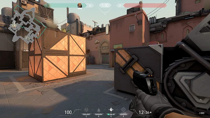 Na powyższym obrazku widać postać, która schowała się za opancerzonym pojazdem, aby osłonić się od potencjalnego ataku z punktu A Short - Valorant: Bind - mapa, callouts dla obrońców i atakujących - Valorant - poradnik do gry