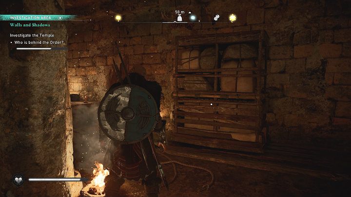 Podejdź do ściany przy której znalazłeś narzędzia chirurgiczne i odsuń regał z pakunkami, by przejść do dalszej części podziemnego kompleksu - Assassins Creed Valhalla: Mury i cienie/Walls and Shadows - solucja - Assassins Creed Valhalla - poradnik do gry