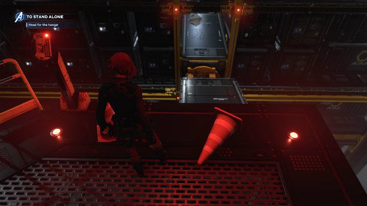 Zanim przejdziesz przez drzwi prowadzące do głównego hangaru odwróć się w prawo w kierunku przewróconego pachołka drogowego - Marvels Avengers: Samotna walka - sekrety, znajdźki - Marvels Avengers - poradnik do gry