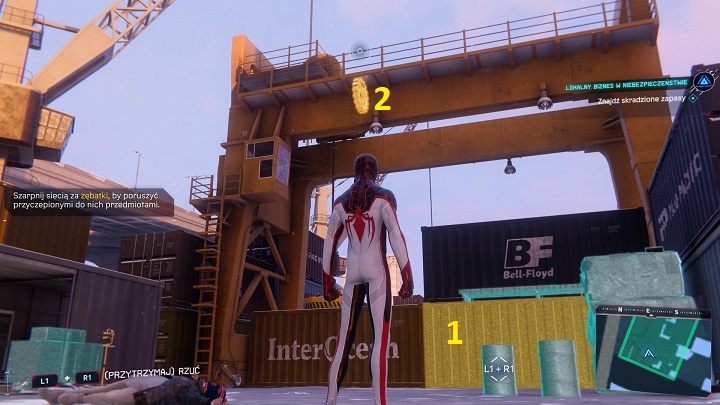 Aby dostać się do kontenera (1) musisz najpierw użyć dźwigni (2), w tym celu wskocz na górę i zablokuj zębatkę - Spider-Man Miles Morales: Lokalny biznes w niebezpieczeństwie - solucja - Spider-Man Miles Morales - poradnik, solucja