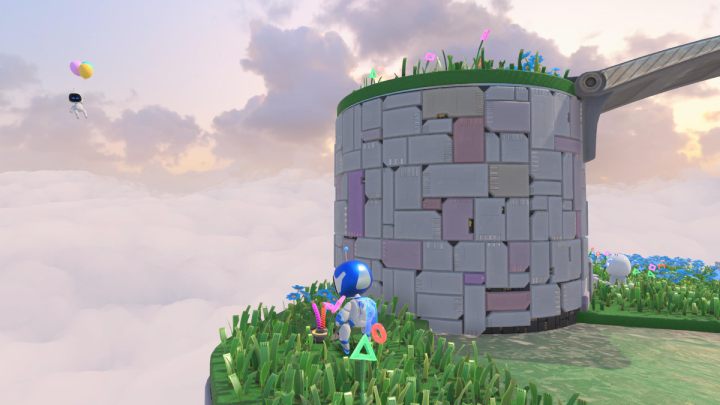 Zeskocz w dół i pociągnij za kable wystające z trawy, aż wyciągniesz element, którym możesz rzucić w bota z balonami, latającego w pobliżu - Astros Playroom: Wietrzna brama - solucja, opis przejścia - Astros Playroom - poradnik do gry