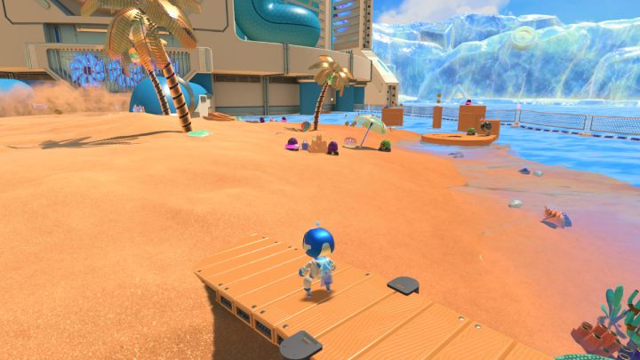 Wróć na wyspę i pokonaj kilku przeciwników chodzących niedaleko zamku z piasku, po prawej części wyspy - Astros Playroom: Plaża botów - solucja, opis przejścia - Astros Playroom - poradnik do gry