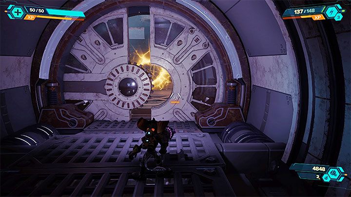 Sekret możecie znaleźć na środkowym poziomie, czyli w obszarze łączącym konstrukcję na powierzchni z podwodnym kompleksem - Ratchet & Clank Rift Apart: Cordelion - znajdźki, lista wszystkich, mapa - Ratchet & Clank Rift Apart - poradnik do gry