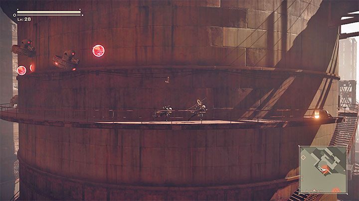 Data Chip E jest na końcu jednego z metalowych balkoników otaczających ogromny silos - NieR Automata: Ruiny miasta - solucja, misje poboczne - NieR Automata - poradnik do gry