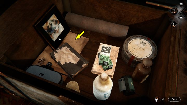 Przesuńcie książkę z poniszczoną okładką i podnieście list znajdujący się pod spodem - Syberia The World Before: Vaghen - schronisko Silberspiegel, jesień 2005 część 1 (Vaghen - Silberspiegel refuge, autumn 2005 part 1) - solucja, opis przejścia - Syberia The World Before - poradnik do gry