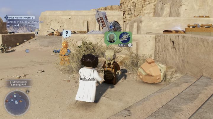 Po wylądowaniu na pustyni na planecie Tatooine, porozmawiajcie ze zleceniodawcą, który będzie stał obok Waszego statku - LEGO Skywalker Saga: Mglista przeszłość Łowcy z Mgieł (Mist Hunter Mystery) - solucja, opis przejścia - LEGO Skywalker Saga - poradnik do gry