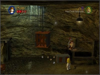 W pomieszczeniu z wywróconym wagonikiem idź w prawo, pokonaj przeciwników i użyj mechanizmu, aby obniżyć klatkę i wypuścić więźnia, który otworzy Ci drzwi - Chapter 4 - Free the Slaves (cz.1) - Świątynia Zagłady - LEGO Indiana Jones: The Original Adventures - poradnik do gry