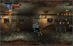 Aby rozpocząć tę misję skieruj się na targ na lewo od pasa startowego, przejdź przez kamienną bramę i wejdź do budynku [1] - Cela w Peru | Kryształowa Czaszka Akt II | LEGO Indiana Jones 2 - LEGO Indiana Jones 2: The Adventure Continues - poradnik do gry