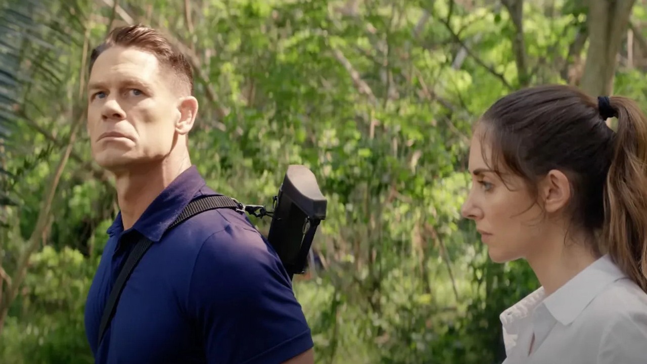 John Cena chroni Alison Brie podczas zamachu stanu w zwiastunie komedii akcji, źródło grafiki: Freelance, Pierre Morel, Signature Films, 2023.