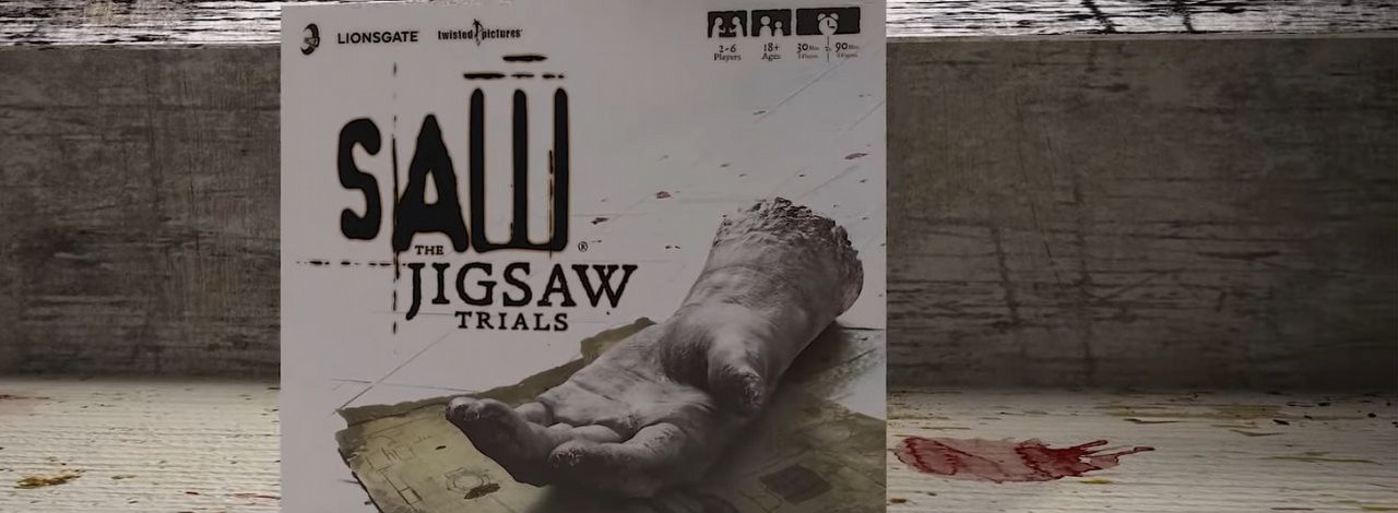 W kolekcjonerce planszówki na podstawie Piły znajdziecie naturalnych rozmiarów uciętą rękę, źródło grafiki: YouTube/Iconiq Studios.